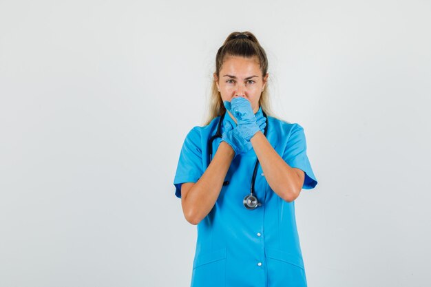 Médica com tosse, de uniforme azul