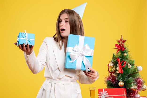 Médica com vista frontal segurando presentes de Natal