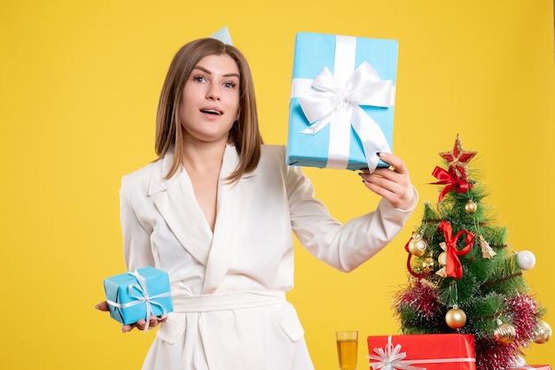 Médica com vista frontal segurando presentes de Natal