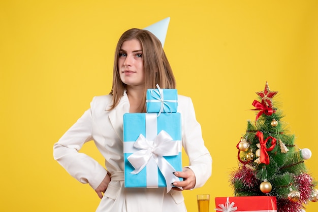 Médica com vista frontal segurando presentes de Natal