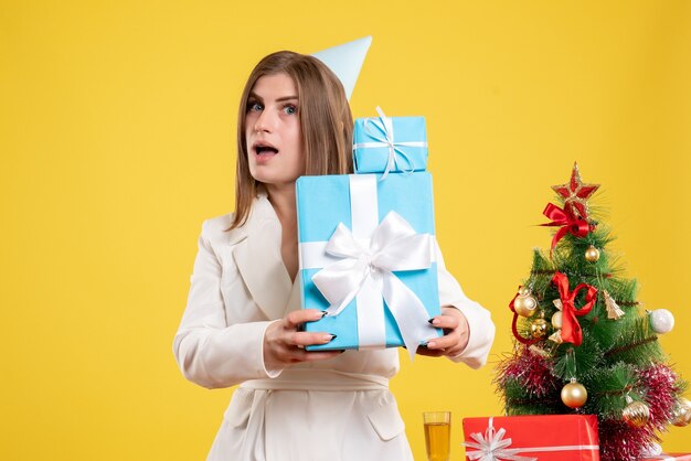 Médica com vista frontal segurando presentes de Natal