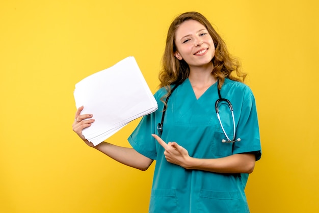 Médica de frente com arquivos no espaço amarelo