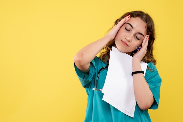 Médica de frente com camisa médica segurando papel de análise, uniforme covid-19 saúde pandêmica em emoção