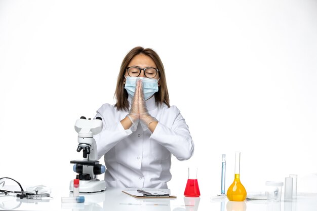 Médica de frente com terno médico branco e máscara devido a cobiçada posando no espaço em branco