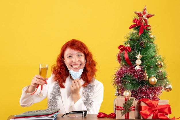 Médica de frente comemorando o natal com taça de champanhe