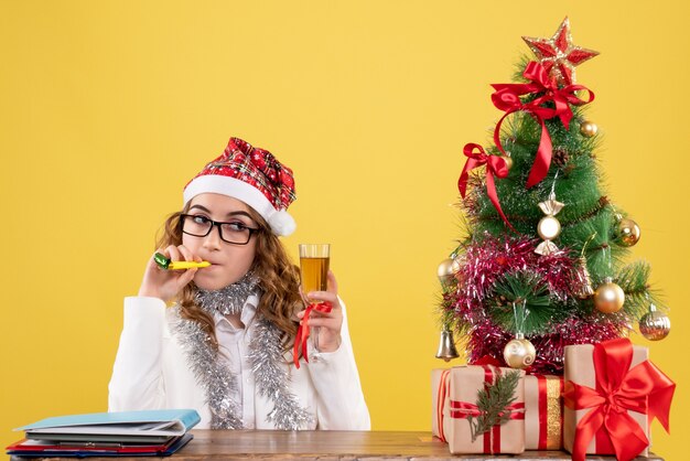 Médica de frente comemorando o natal com taça de champanhe