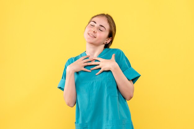 Médica de frente encantada com o fundo amarelo hospital médico saúde emoção