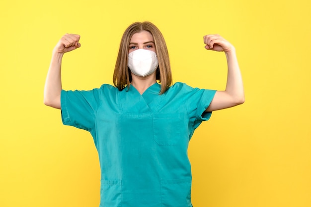 Foto grátis médica de frente flexionando no espaço amarelo