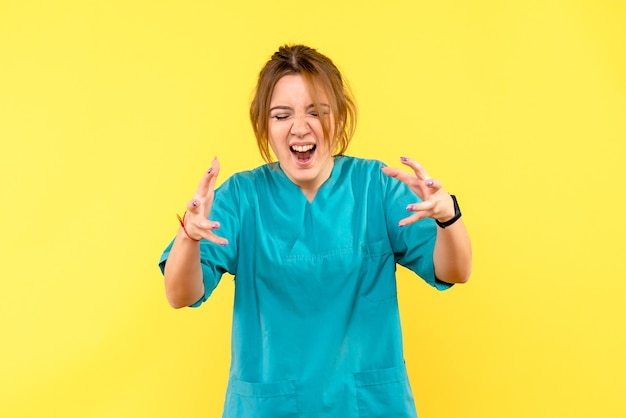 Médica de frente gritando no espaço amarelo