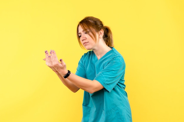 Médica de frente, imitando leitura no espaço amarelo