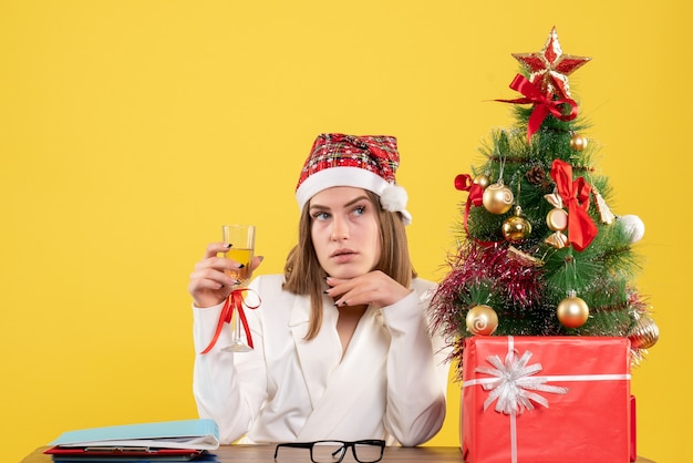 Médica de frente para comemorar o natal com champanhe