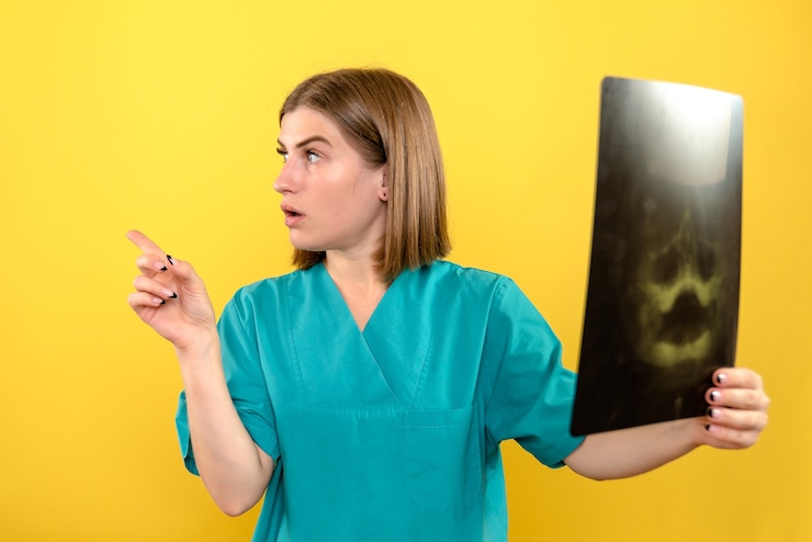 Foto grátis médica de frente segurando um raio-x no espaço amarelo