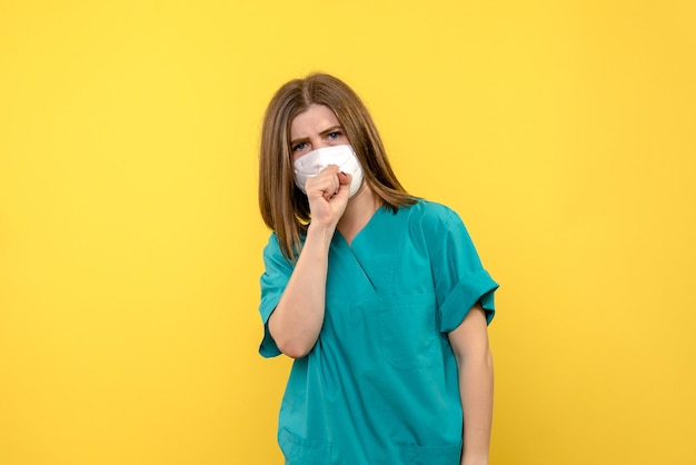 Médica de frente tossindo no espaço amarelo