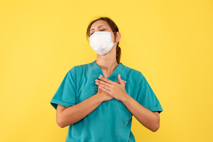 Foto grátis médica de vista frontal com camisa médica e máscara em fundo amarelo