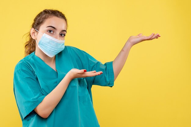 Médica de vista frontal com camisa médica e máscara estéril, cor uniforme de vírus da saúde covid-