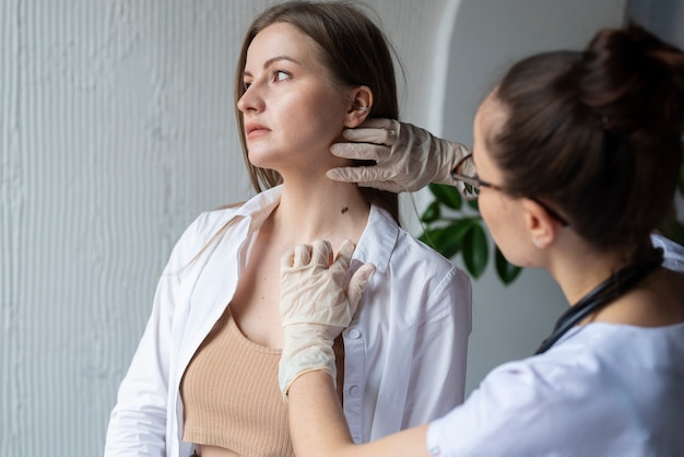 Médica diagnosticando um melanoma no corpo de uma paciente do sexo feminino