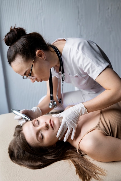 Médica diagnosticando um melanoma no corpo de uma paciente do sexo feminino