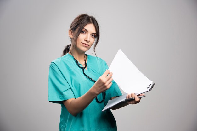 Médica posando com estetoscópio e prancheta