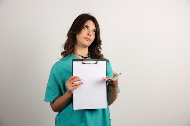 Médica posando com uma prancheta em branco