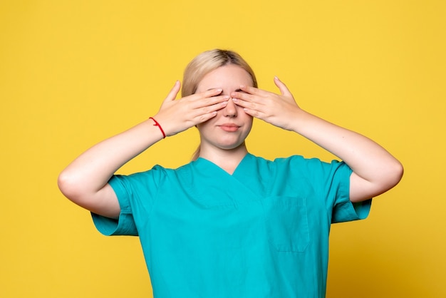 Médica vista frontal com camisa médica cobrindo os olhos, enfermeira cobiçada com emoção pandêmica