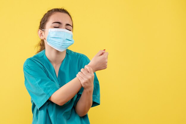 Médica vista frontal com camisa médica e máscara com braço ferido, uniforme covid-19 do vírus da saúde pandêmico colorido