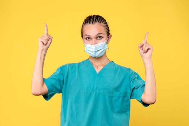 Médica vista frontal com camisa médica e máscara estéril, enfermeira de saúde, hospital pandêmico de vírus covid-19 médico