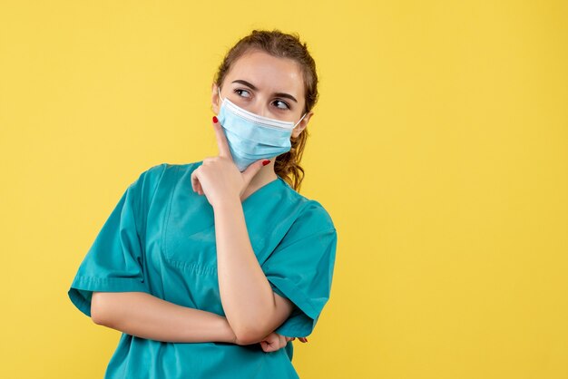 Médica vista frontal com camisa médica e máscara estéril, vírus uniforme covid-19 coronavírus saúde