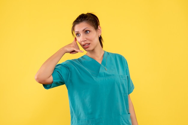 Médica vista frontal com camisa médica no fundo amarelo