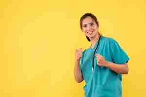 Foto grátis médica vista frontal com camisa médica sorrindo sobre fundo amarelo