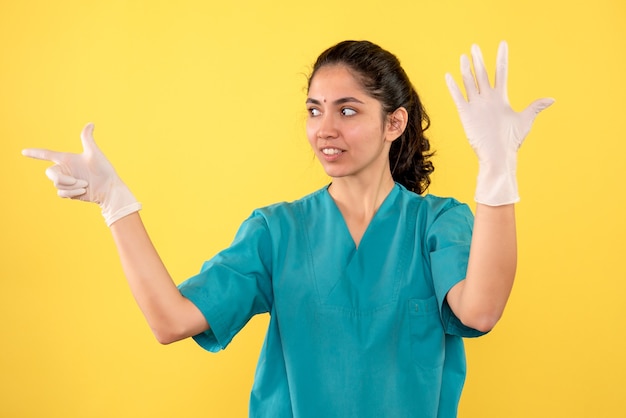 Médica vista frontal com luvas de látex abrindo as mãos