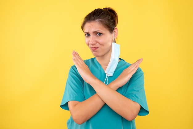 Foto grátis médica vista frontal com máscara em fundo amarelo