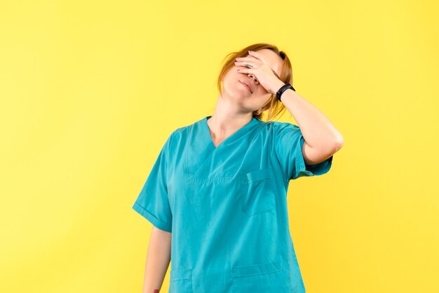 Médica vista frontal estressada no espaço amarelo