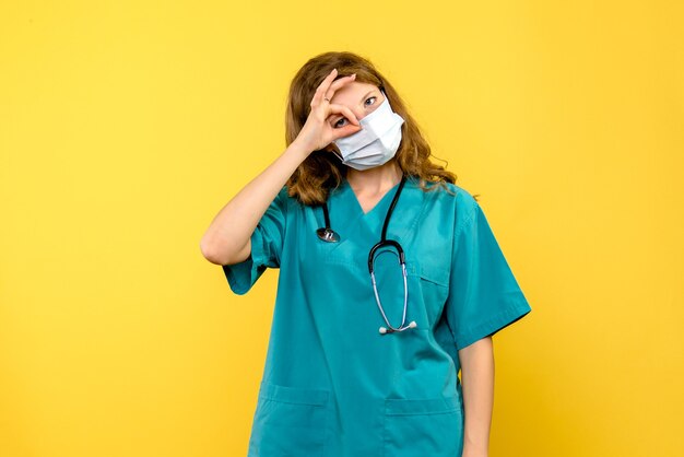 Médica vista frontal olhando através do dedo no espaço amarelo