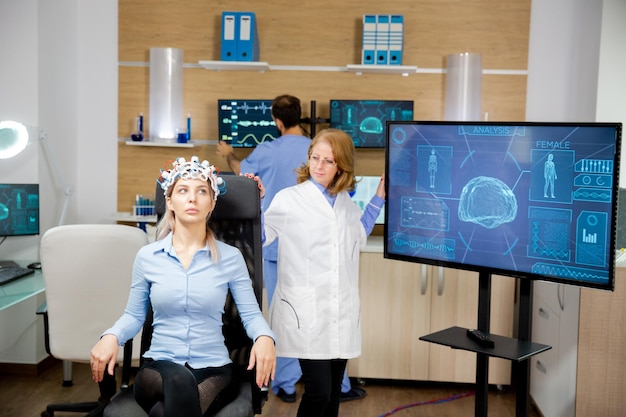 Médico acompanhando a evolução do paciente durante o teste de neurologia com fone de ouvido. Centro neorológico