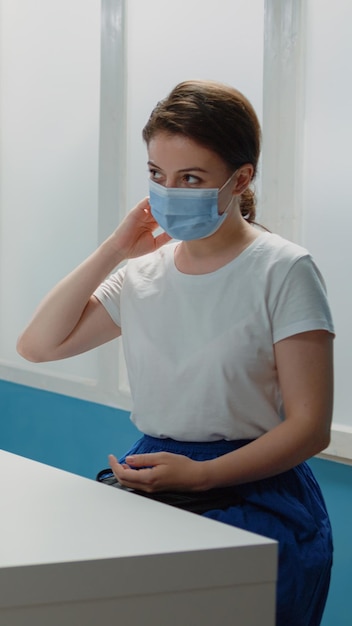 Médico afro-americano consultando paciente caucasiano. Médico negro falando com mulher sobre saúde para visita anual de check-up enquanto usava máscaras faciais para proteção contra coronavírus