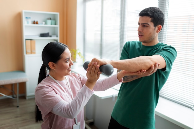 Foto grátis médico ajudando paciente durante a reabilitação