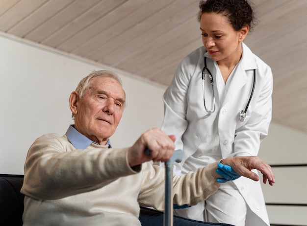 Foto grátis médico ajudando seu antigo paciente a se levantar