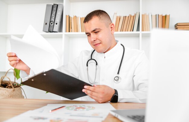 Médico bonitão segurando uma prancheta