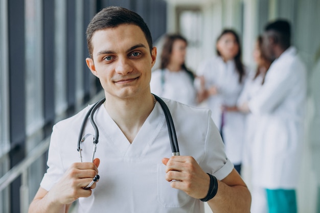 Médico caucasiano homem parado no corredor do hospital