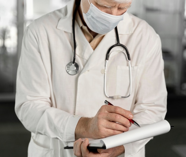 Médico com máscara médica verificando suas anotações
