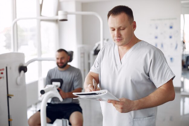 Médico com paciente em clínica de fisioterapia