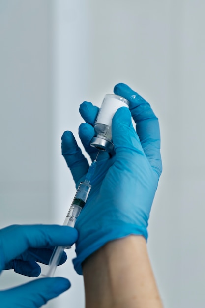 Foto grátis médico com seringa e frasco de anestesia