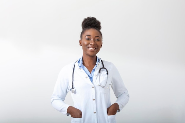 Médico com uma mão de estetoscópio no bolso Close de uma mulher sorrindo em pé em linha reta no fundo branco