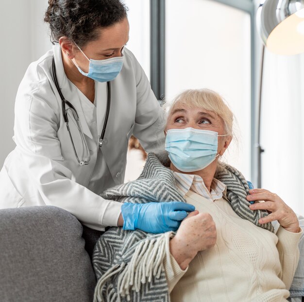 Médico cuidando de mulher idosa