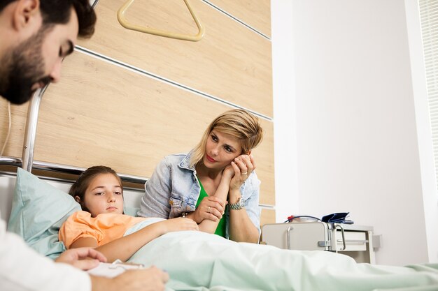 Médico dando a notícia a seu paciente e sua mãe no hospital
