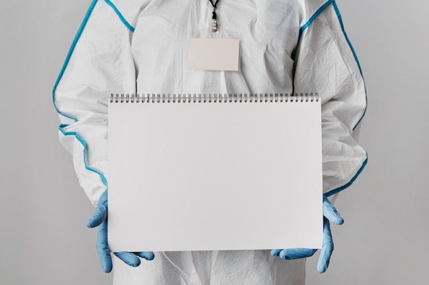 Foto grátis médico de frente segurando um caderno em branco