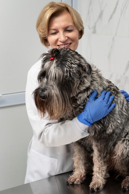 Foto grátis médico de tiro médio abraçando cachorro