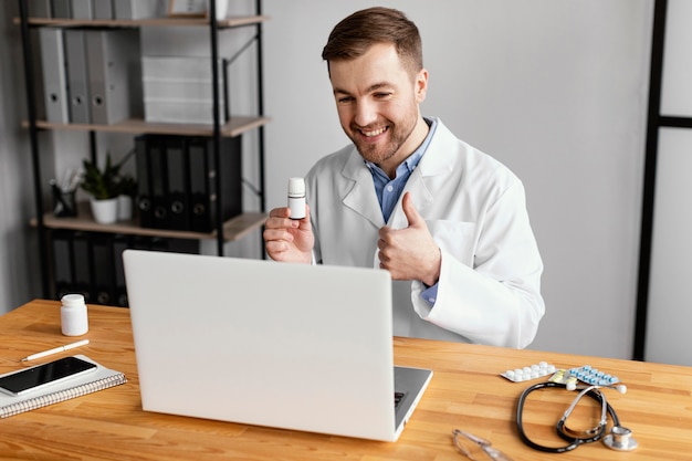 Foto grátis médico de tiro médio com polegar para cima