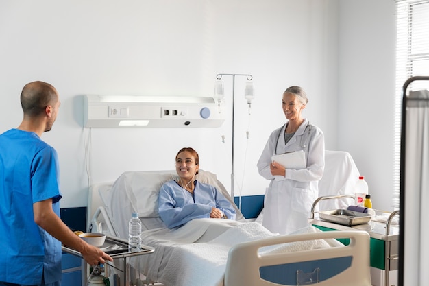 Foto grátis médico de tiro médio e enfermeiro com paciente