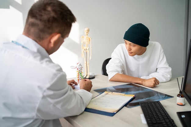 Foto grátis médico de tiro médio falando com o paciente